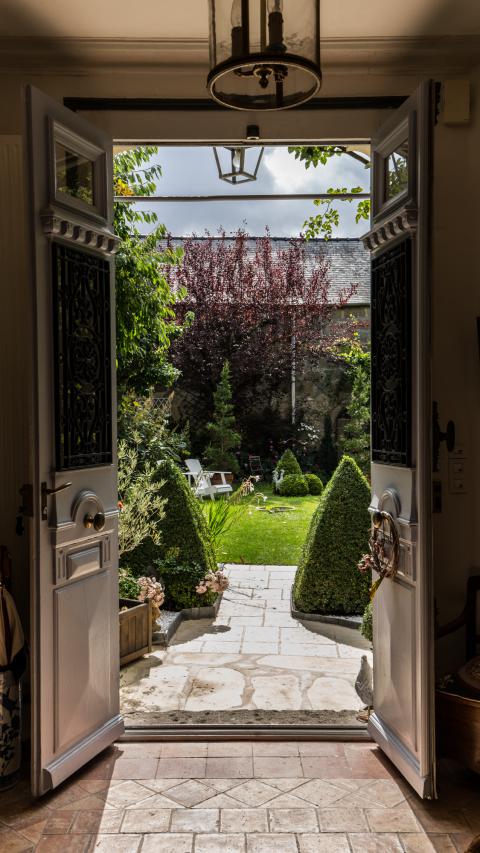 Photo porte ancienne ouverte sur un jardin au soleil